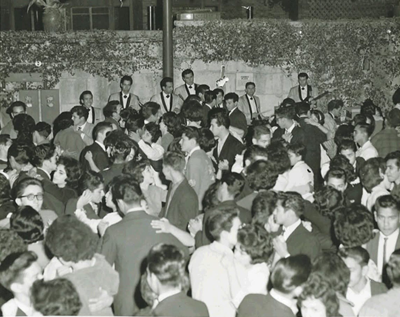 Historic dance hall filled with couples dancing while a band performs