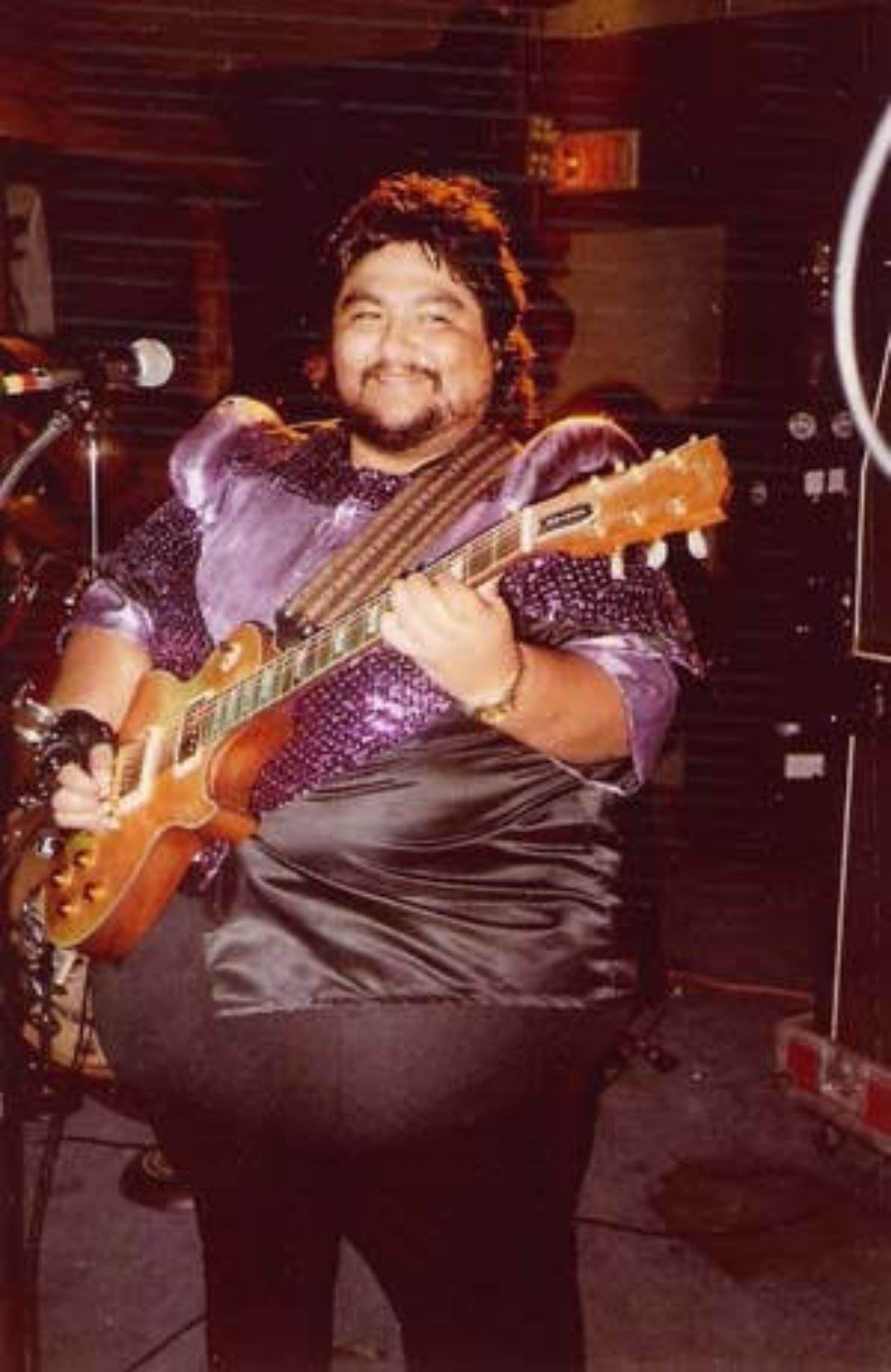 Historic photo of a Tejano guitarist smiling onstage